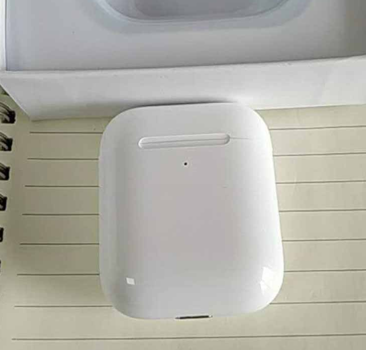 i80 TWS Bluetooth Earbuds with Wireless Charging charging case on a notebook.