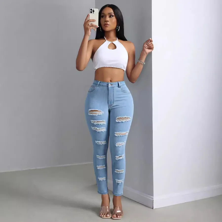 Fashion Personality Women's Ripped Jeans Trousers worn by a stylish woman holding a phone, showcasing trendy ripped design.