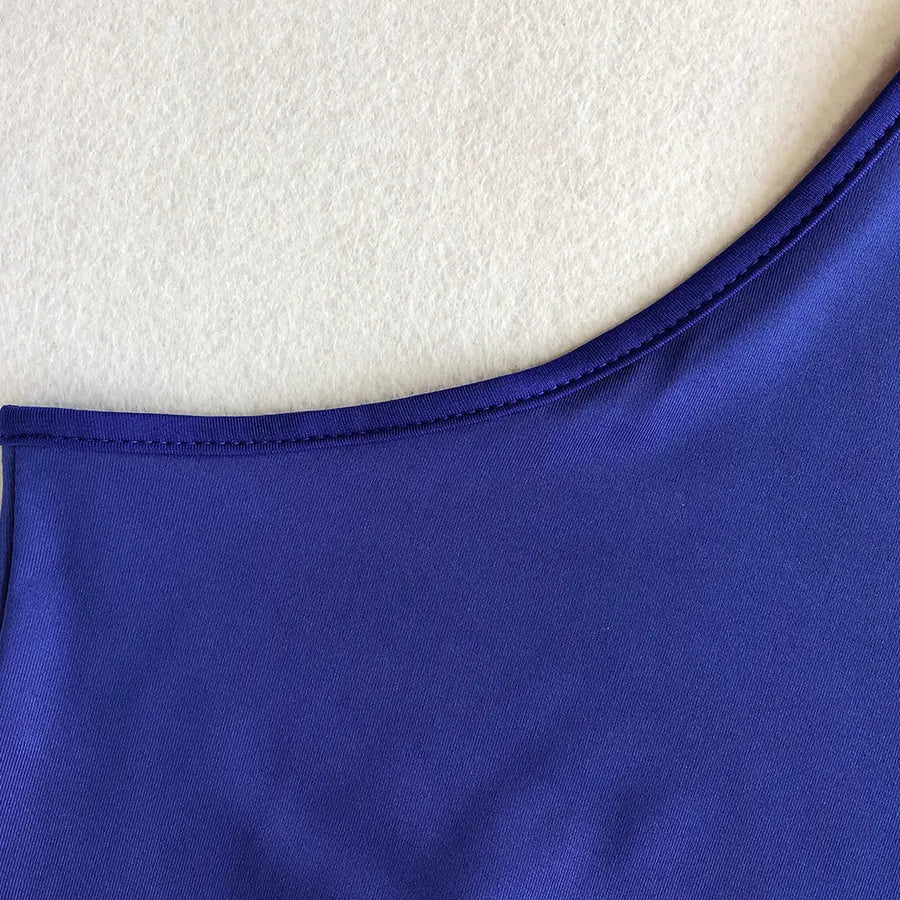 Backless Strappy Irregular Jumpsuit close-up of the neckline in vibrant purple fabric.