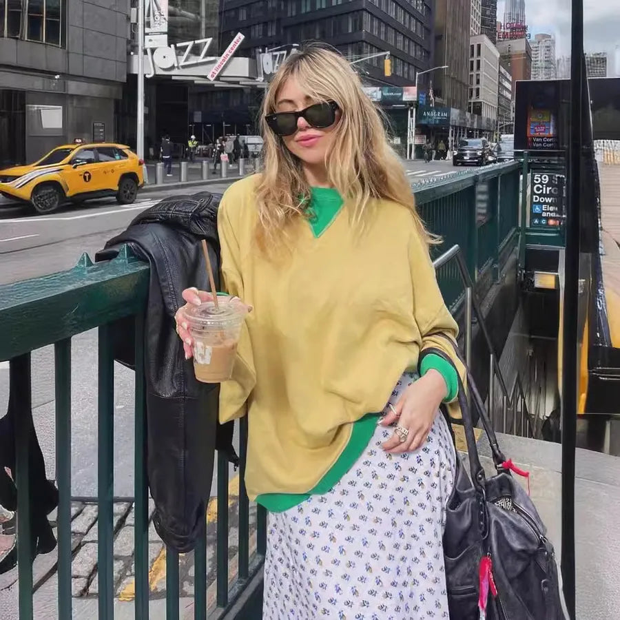 Loose Casual Contrast Color Sweater For Women styled with a floral skirt and sunglasses in an urban setting.