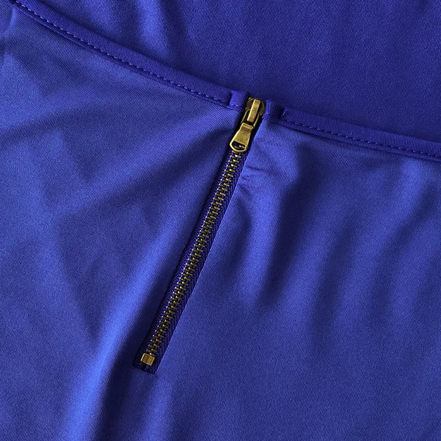 Close-up detail of the zipper on a Backless Strappy Irregular Jumpsuit in vibrant blue.